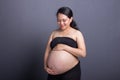 During maternity childbearing woman in black clothes caresses her belly