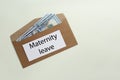 Maternity leave concept. Envelope with dollar banknotes and note on white background, top view. Space for text Royalty Free Stock Photo