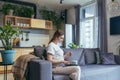 Maternity leave. Work. Pregnant freelancer woman sitting at home on sofa with laptop in home clothes. Works on the computer Royalty Free Stock Photo