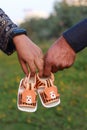 Maternity shoot picture couple holding shoes