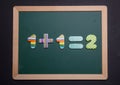 Math simple addition on green board with wooden frame, black background