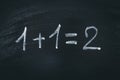 Math simple equation on chalk board. One plus One equals two