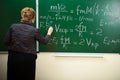 Math teacher writing formula on the blackboard Royalty Free Stock Photo