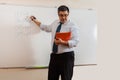 A mathematics teacher writes on a blackboard