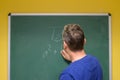 Mathematics teacher writing formula on chalkboard