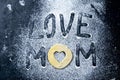 Mather Day Concept. Word LOVE MOM making from the flour and dough on dark background. Top views, close-up Royalty Free Stock Photo