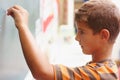 Maths genius in the making. Young boy writing the answer to a question on the chalkboard - copyspace. Royalty Free Stock Photo