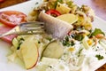 Matjes herring with yoghurt dressing, fruits and fried potatoes Royalty Free Stock Photo