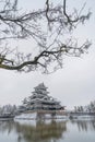Matsumoto Castle with tree branches and snow in winter season, Nagano, Japan. Architecture landscape background in travel trip Royalty Free Stock Photo