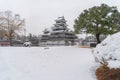 Matsumoto Castle with tree branches and snow in winter season, Nagano, Japan. Architecture landscape background in travel trip Royalty Free Stock Photo