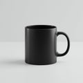 A matte black ceramic mug with a cylindrical shape and a sturdy handle is centered Royalty Free Stock Photo