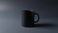 A matte black ceramic mug is situated on a dark monochrome surface Royalty Free Stock Photo