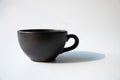Matte black coffee cup with natural sunlight and black shade with isolated white background Royalty Free Stock Photo