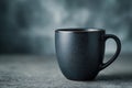 Black coffee in a matte black mug sits elegantly on a textured surface, surrounded by a modern abstract background, creating a Royalty Free Stock Photo