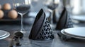 Matte black napkin holders with abstract triangular patterns etched into the surface