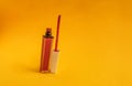 Matte bright lipstick in a glass tube on a yellow matte background. liquid lipstick, with a soft brush for applying gloss to the Royalty Free Stock Photo