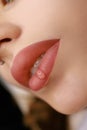 Matte effect of the lips after the procedure of permanent makeup of the lips. On the lips of the girl a drop of oil for