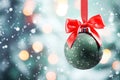 matte green Christmas ball with red bow a snowy background of bokeh lights on a Christmas tree Royalty Free Stock Photo