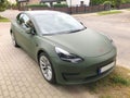 Darlowo, Poland, July 2022 : EV green Tesla car parked on pavement