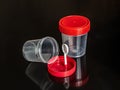 Matte plastic containers with red lids on a dark background Royalty Free Stock Photo