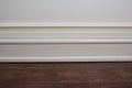Matte wall, white baseboard and tiles immitating hardwood flooring Royalty Free Stock Photo