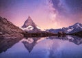 Matterhorn and reflection on the water surface at the night time. Milky way above Matterhorn, Switzerland.