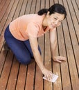 Matue woman sanding natural cedar wooden deck by hand