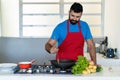 Mature adult hispanic chef cooking at kitchen