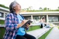 Mature adult student sitting in front off College building and reading school books after attending a university class, Adult Royalty Free Stock Photo