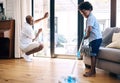 Mature african american dad and his young little son doing housework in the lounge at home. Black man and his boy having Royalty Free Stock Photo