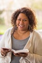 Mature African American woman sitting outside reading. Royalty Free Stock Photo