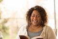 Mature African American woman sitting outside reading. Royalty Free Stock Photo
