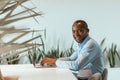 Mature african businessman workingon on laptop while sitting in modern coworking