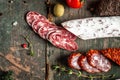 Mature air dried sausage, Fuet fresh and sliced on wooden board closeup. Spanish traditional sausage sliced on a wooden board.