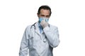 Mature american doctor with stethoscope touching his respirator mask. Royalty Free Stock Photo