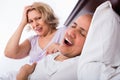 Mature angry girlfriend cannot stand guy snoring loudly Royalty Free Stock Photo