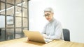 Mature asian business woman wears glasses using laptop computer sit at workplace desk Royalty Free Stock Photo