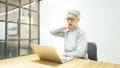 Mature asian business woman wears glasses using laptop computer sit at workplace desk Royalty Free Stock Photo