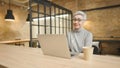 Mature asian business woman wears glasses using laptop computer sit at workplace desk Royalty Free Stock Photo