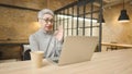 Mature asian business woman wears glasses using laptop computer sit at workplace desk Royalty Free Stock Photo