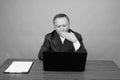 Mature Asian businessman sitting with wooden table against gray background Royalty Free Stock Photo