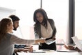 Mature asian female coach giving handout materials during corporate seminar Royalty Free Stock Photo