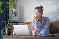 Mature asian woman working from home using laptop computer and cellphone Royalty Free Stock Photo