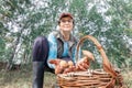 Mature athletic woman picking mushrooms in a large forest