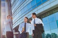 Mature attractive businessmen walking while talking against office building after work