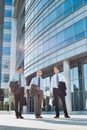 Mature attractive businessmen walking while talking against office building after work