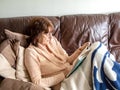 Mature attractive lady laying on sofa reading a book to relax Royalty Free Stock Photo