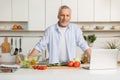 Mature attractive man standing at the kitchen cooking Royalty Free Stock Photo