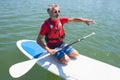 Mature attractive rider contemplating nature sitting on paddle board