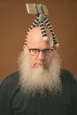 Mature bald man with long gray beard vlogging with phone Royalty Free Stock Photo